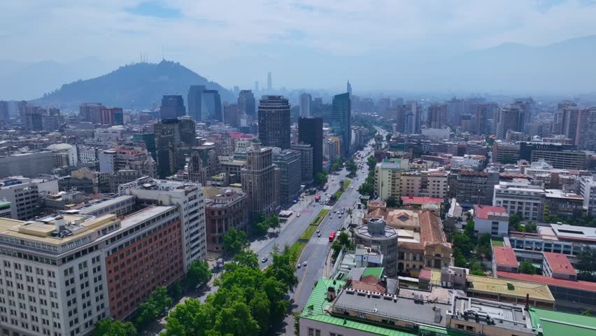Static Aerial Shot of Santiago City Center with Tree-Lined Avenue, Modern Towers, and Andes Mountains in the Distance