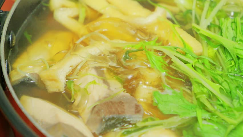 Japanese hot pot dish made with yellowtail fish, udon noodles, mizuna greens, and green onions