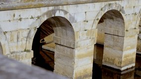Stone arches of an old bridge cast reflections on the canal water below - Powered by Shutterstock - Get 15% off with code: PIKWIZARD15