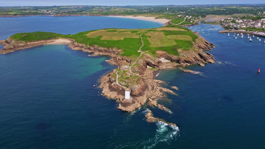Kermorvan peninsula, historic fort, lighthouse, Le Conquet harbor, and Plage des Blancs Sablons beach in Brittany, France. Aerial forward