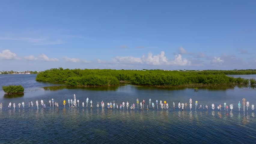 Aerial view of channel markers in the tranquil waters reflecting the blue sky, contrasting with the lush green mangrove islands, Islamorada, Florida, United States.