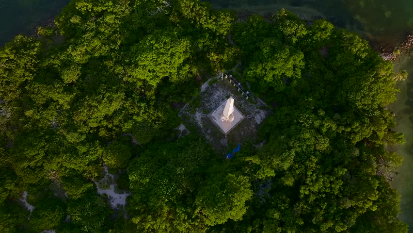 Aerial view of a prominent Flagler Monument standing tall on a vibrant green island, contrasting with the surrounding deep blue waters, Miami Beach, Florida, United States.