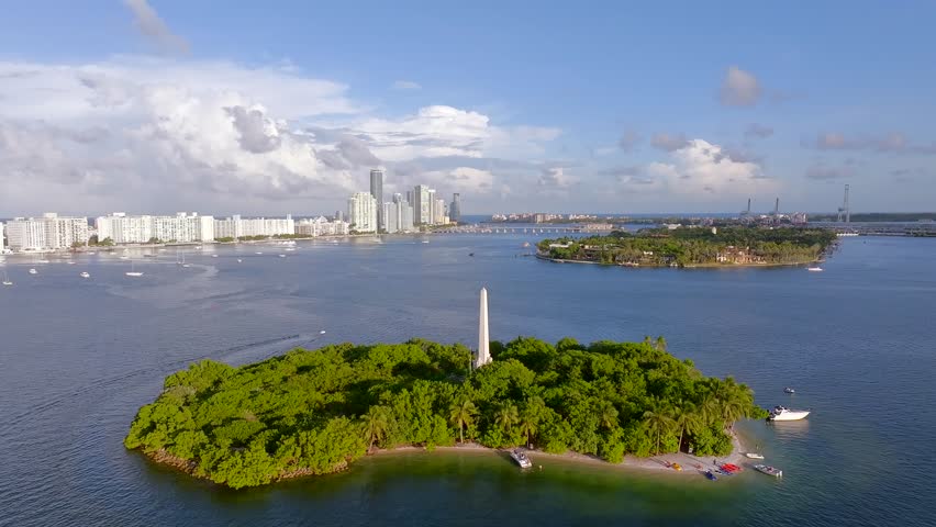 Aerial view of Flagler Monument Island, where the lush green island contrasts with the calm waters and Miami Beach skyline, Miami Beach, Florida, United States.