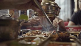 Hand cooking smoked grilled pork on iron grill pan in Korean BBQ in restaurant. Traditional Korea style food barbecue pork belly steak on charcoal grill. - Powered by Shutterstock - Get 15% off with code: PIKWIZARD15
