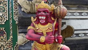 Vivid close-up of colorful Hanuman statue guarding temple entrance in Bali, Indonesia. Hindu monkey deity with golden crown and mace stands in front of temple doors. - Powered by Shutterstock - Get 15% off with code: PIKWIZARD15