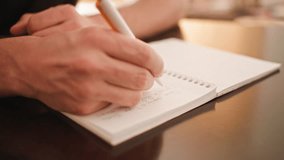 A close up shot of a person's hand writing something in English with a pen in longhand. The video has beautiful natural lighting and great visual aesthetic quality. - Powered by Shutterstock - Get 15% off with code: PIKWIZARD15