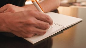 A close up shot of a person's hand writing something in English with a pen in longhand. The video has beautiful natural lighting and great visual aesthetic quality. - Powered by Shutterstock - Get 15% off with code: PIKWIZARD15
