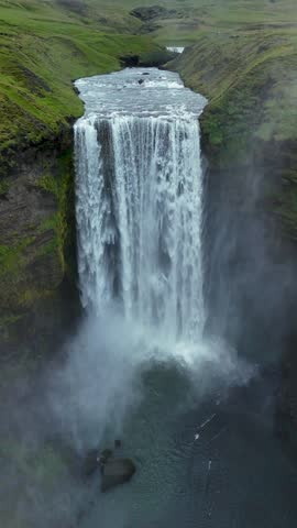 Dramatic landscape of Skogafoss waterfall flowing from a volcanic mountain in southern Iceland during summer