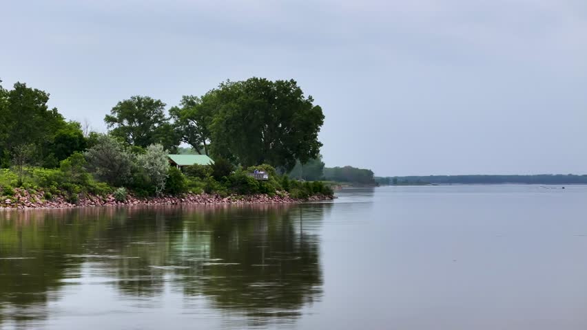 An aerial view of the Missouri River near Vermillion, South Dakota, with lush summer trees, winding shoreline, and layered depth.
