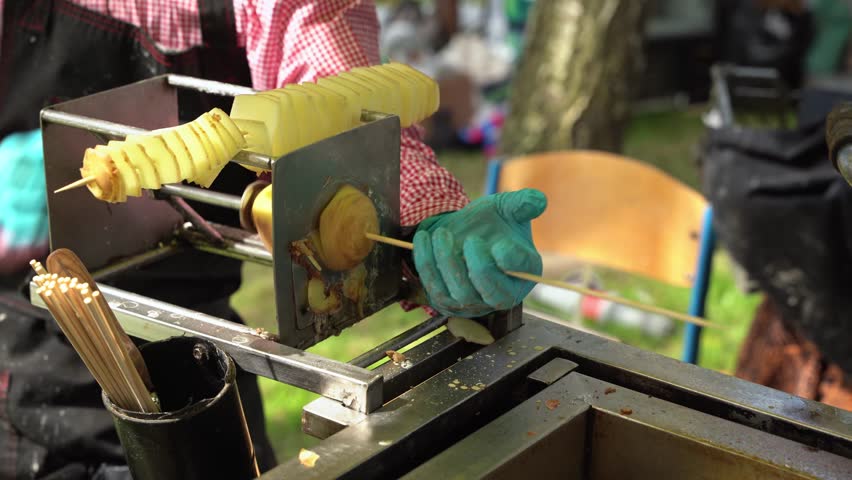 Street food vendor preparing tornado potato skewers