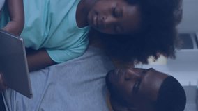 Animation of data processing over african american father and son using tablet on the couch at home. Fatherhood, love and technology concept - Powered by Shutterstock - Get 15% off with code: PIKWIZARD15