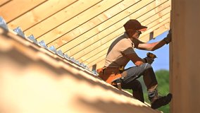 A worker climbs on a roof to repair it, using various tools while wearing safety gear. The sun shines brightly, highlighting the construction site. - Powered by Shutterstock - Get 15% off with code: PIKWIZARD15