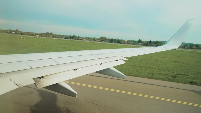 Jet rolling down runway after landing. Plane taxiing along tarmac post-touchdown. Aircraft moving on landing strip heading toward terminal area