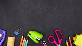 Colorful school supplies bottom border. Top down view stop motion video over a black chalkboard background. Back to school concept. - Powered by Shutterstock - Get 15% off with code: PIKWIZARD15