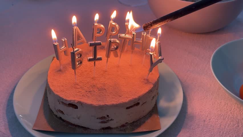 Lighting happy birthday candles on cake with lighter during celebration