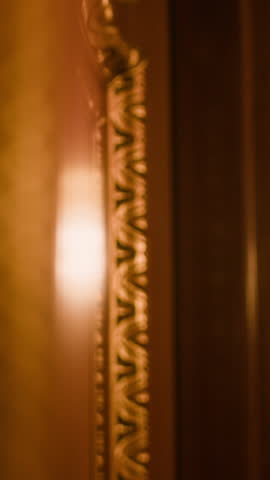 Vertical close-up of intricately carved wooden door featuring vintage brass knocker labeled 25 and peephole below, framed with elegant gold detailing and floral inlay