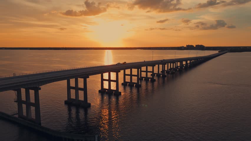 Caloosahatchee Bridge spanning river with traffic in Fort Myers, sunset aerial