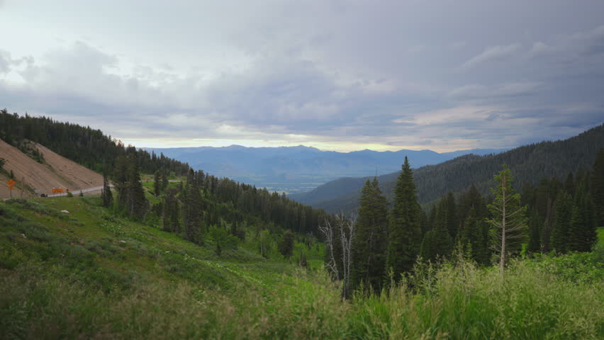 Embark on an unforgettable journey to Grand Teton National Park in Wyoming, exploring its stunning landscapes of green hills, towering trees, and majestic mountains touching the sky