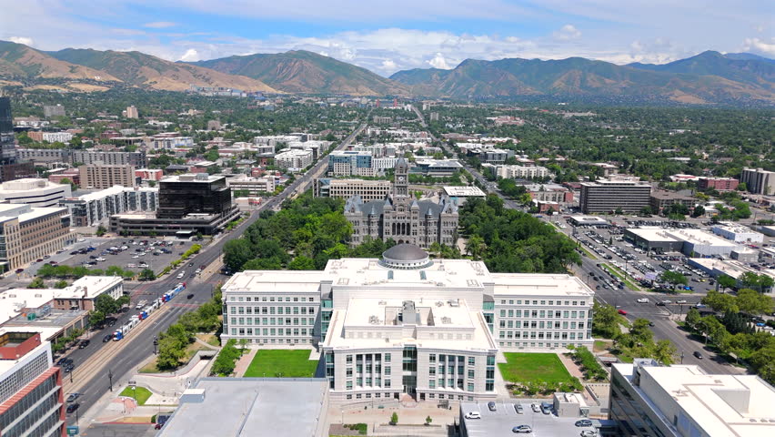 Stunning aerial views showcase Salt Lake Citys vibrant skyline, featuring lush greenery, impressive architecture, and majestic mountains in the background, creating a breathtaking landscape