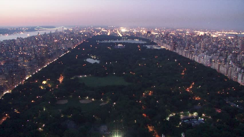Central Park at dusk, with city skyline lit in the background