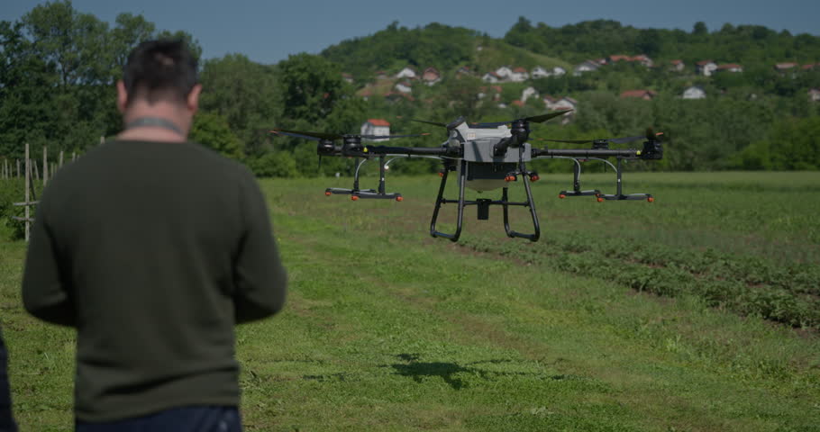 An agricultural drone monitors crop rows in a scenic mountain valley, showcasing smart farming, precision agriculture, and innovative technology for sustainable growth and efficient crop management
