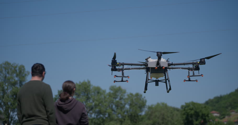 An agricultural drone monitors crop rows in a scenic mountain valley, showcasing smart farming, precision agriculture, and innovative technology for sustainable growth and efficient crop management