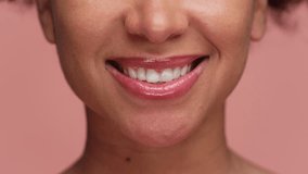 Close-up of young woman smiling with perfect teeth on pink - Powered by Shutterstock - Get 15% off with code: PIKWIZARD15