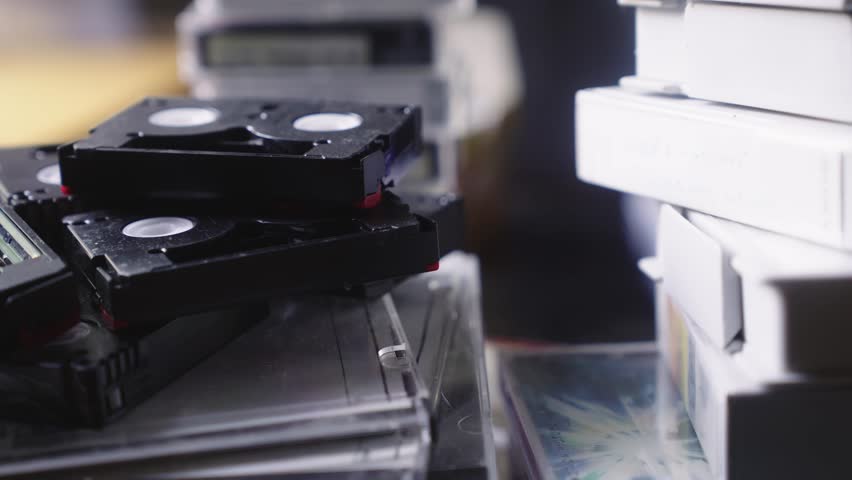 Stacks of digital video cassette tape recordings on office desk PUSH Shot