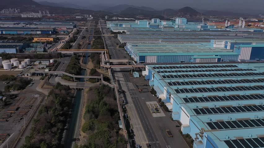 a large ship in a port with a factory