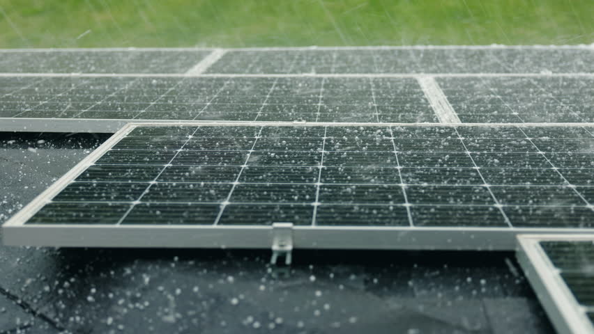 Hailstorm striking solar panels during heavy rain, highlighting the durability and weather resistance of solar energy systems in diverse environmental conditions. High quality 4k footage