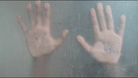 Two palms are pressed against a frosted, glass-like surface, creating a faint silhouette with a dramatic effect. One hand appears to have a pen or scribble on its palm, creating a mysterious and artis - Powered by Shutterstock - Get 15% off with code: PIKWIZARD15