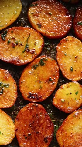 Pan-frying potato slices in hot oil until golden brown. Top view shot