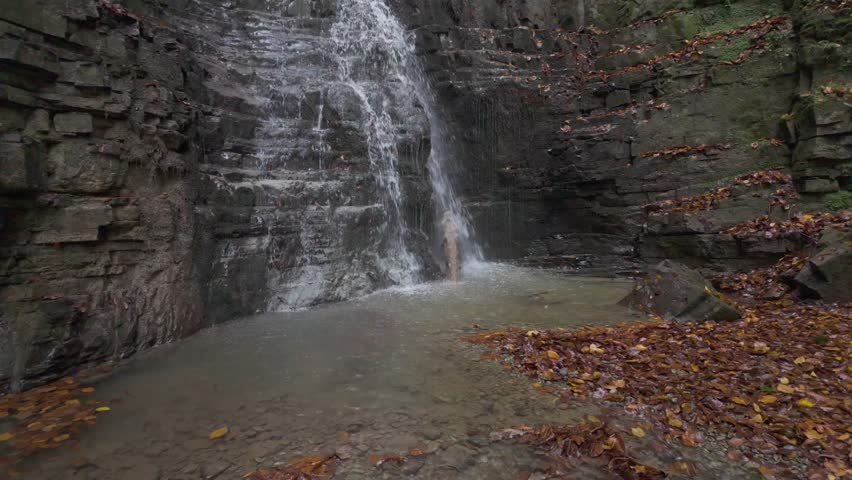 Ukraine, Carpathian Mountains, a small waterfall in an orange autumn forest near a large waterfall Bukhtivets, Pasichna village, Nadvirna city