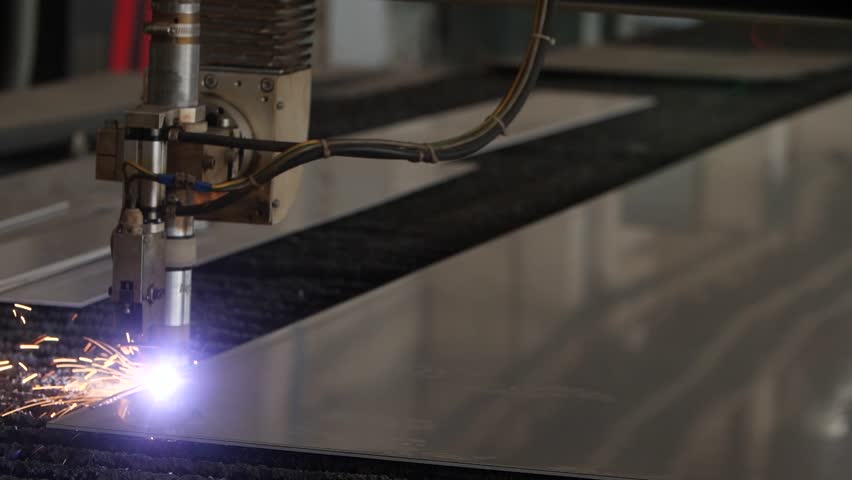 Industrial laser cutter slices through metal sheet, generating vivid sparks during automated fabrication process. Innovation technology of industrial manufacturing in workshop. Metalworking industry.