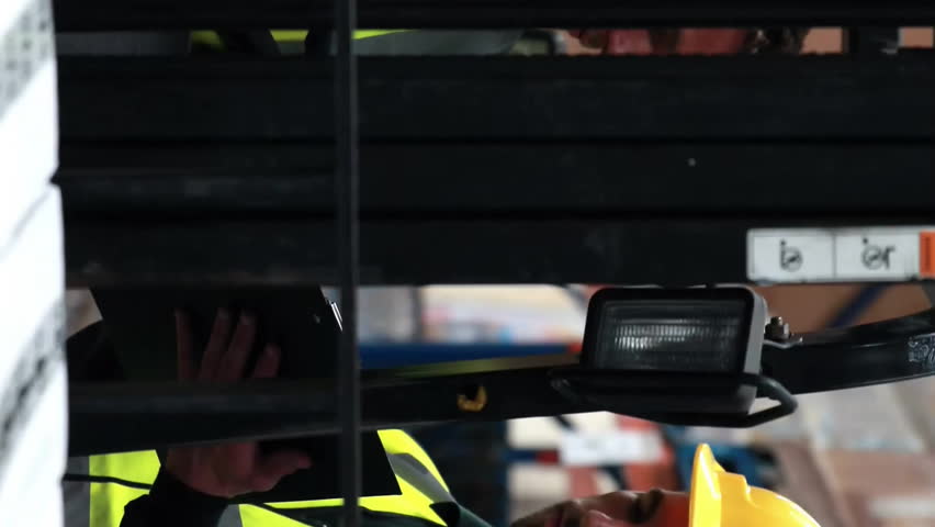 Operating forklift with digital interface, workers in safety gear in warehouse. Logistics, supply chain, industrial, technology, transportation, machinery - Powered by Shutterstock - Get 15% off with code: PIKWIZARD15