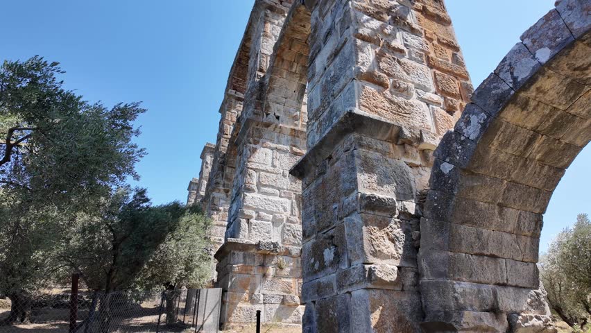 Moria, Island Lesvos, Greece - July 15th, 2025 - footage of traditional island village, ancient roman aqueduct, greek churches, houses, streets, roofs, valley and mountains 