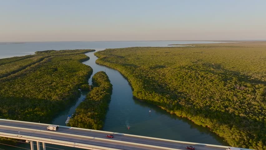 Aerial view of the highway over the waterway surrounded by lush green vegetation and blue water, Key Largo, Florida, United States.