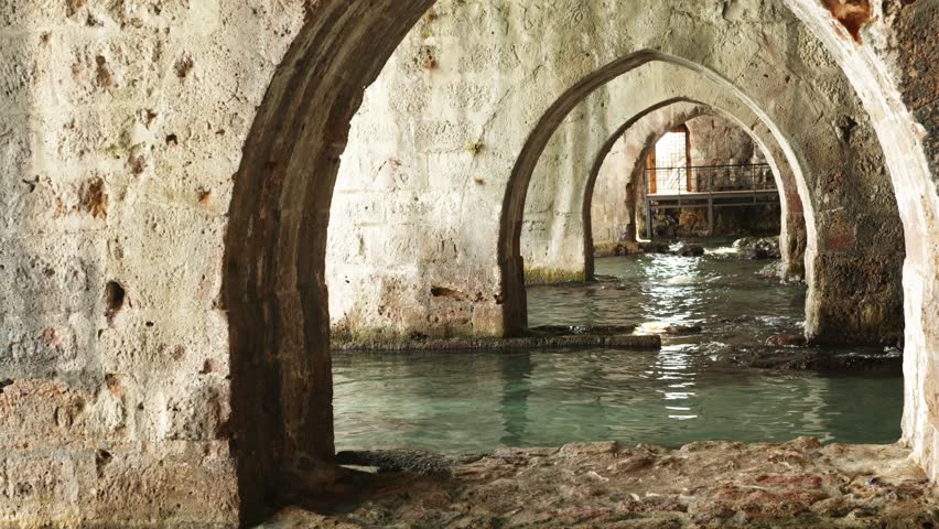 Discover the beauty of old stone arches in Alanya Shipyard beside tranquil waters at a historic coastal site in this hidden gem.