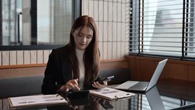 Young businesswoman using calculator and smartphone for calculating finance, tax, accounting, statistics and analytic research document at office desk - Powered by Shutterstock - Get 15% off with code: PIKWIZARD15
