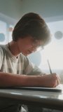 Elementary School Students Writing Exam on Renewable Energy Resources in Classroom. Female Teacher Walking Between Desks, Controlling Young Boys and Girls During School Test Process. Vertical Shot. - Powered by Shutterstock - Get 15% off with code: PIKWIZARD15