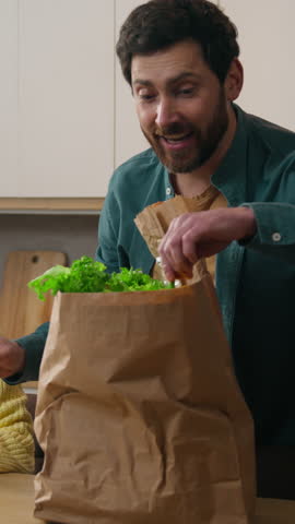 Parent father smiling in kitchen happy Caucasian child girl kid daughter helping dad unpacking delivered vegetables vitamin tasty healthy nutrition products shopping bag paprika pepper tomatoes bread
