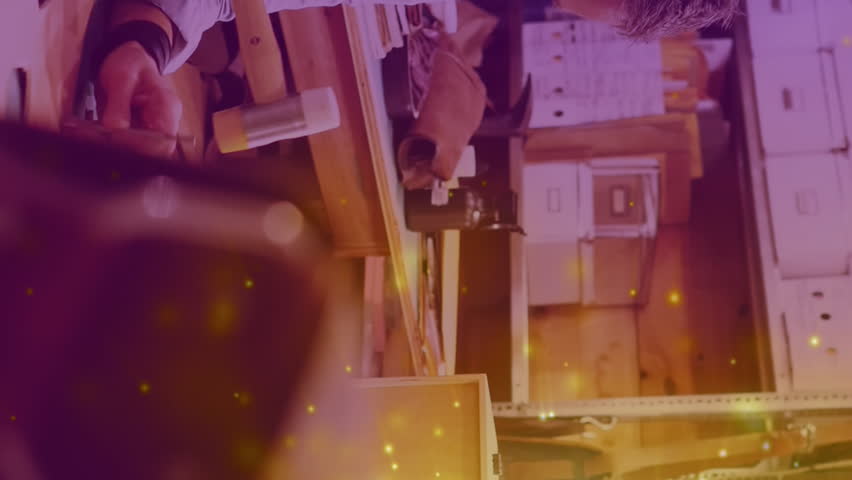 Animation of glowing light over caucasian woman working in workshop. labor day, work, workers, tradition and celebration concept digitally generated video.