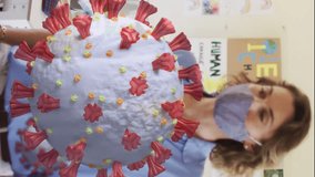 Animation of covid 19 cells and female teacher and children in classroom wearing face masks. healthcare and protection during coronavirus covid 19 pandemic, digitally generated video - Powered by Shutterstock - Get 15% off with code: PIKWIZARD15