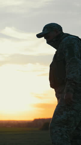 Two soldiers walk shoulder to shoulder at dusk. United by purpose, they return from patrol as the sunset paints the sky behind them.