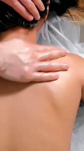 Massage therapist applies therapeutic massage techniques to relieve back pain and tension, reducing stress and improving overall body relaxation in clinic.