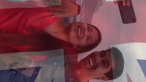 Animation of flag of uk flag over happy diverse couple taking selfie by sea. American patriotism, independence and diversity concept digitally generated video. - Powered by Shutterstock - Get 15% off with code: PIKWIZARD15