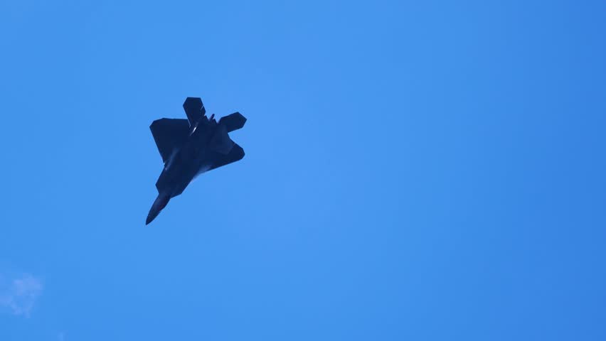 The F-22 Raptor jet performs combat maneuvers and releases flares during the airshow.