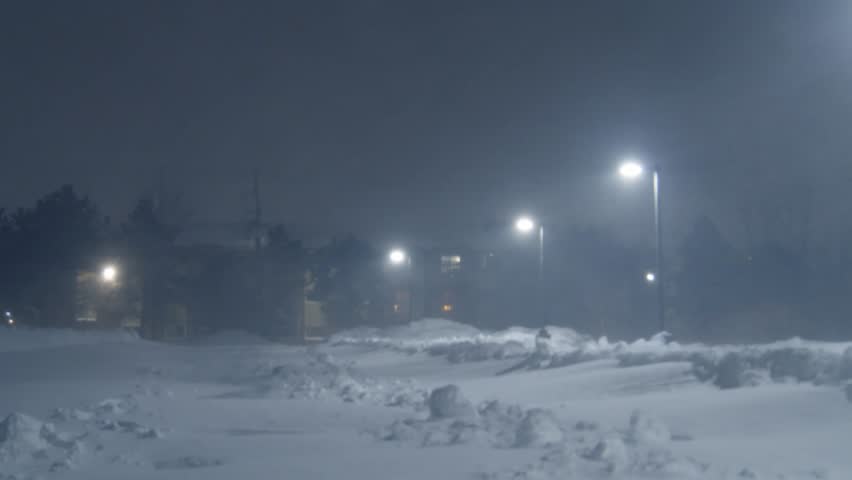 Intense Snowstorm Blankets The Road In Dartmouth, Nova Scotia, Canada, As Vehicles Struggle Through Thick Snow Under A Glowing Streetlamp. Visibility Drops As Flakes Swirl In The Cold Winter Wind.