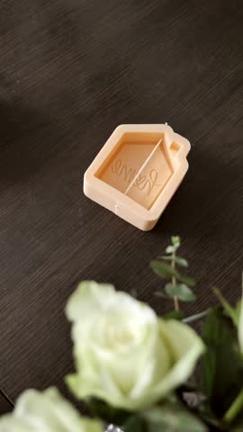 Making a wax candle , handmade, pouring melted hot wax into a silicone mold with the inscription home. Vertical, close-up