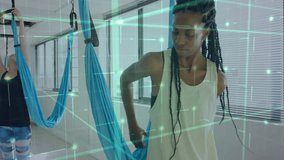 After securing silk at back, woman initiating yoga balance pose with green AR grid for fitness. Aerial yoga, fitness studio, balance, flexibility, meditation, wellness, modern - Powered by Shutterstock - Get 15% off with code: PIKWIZARD15